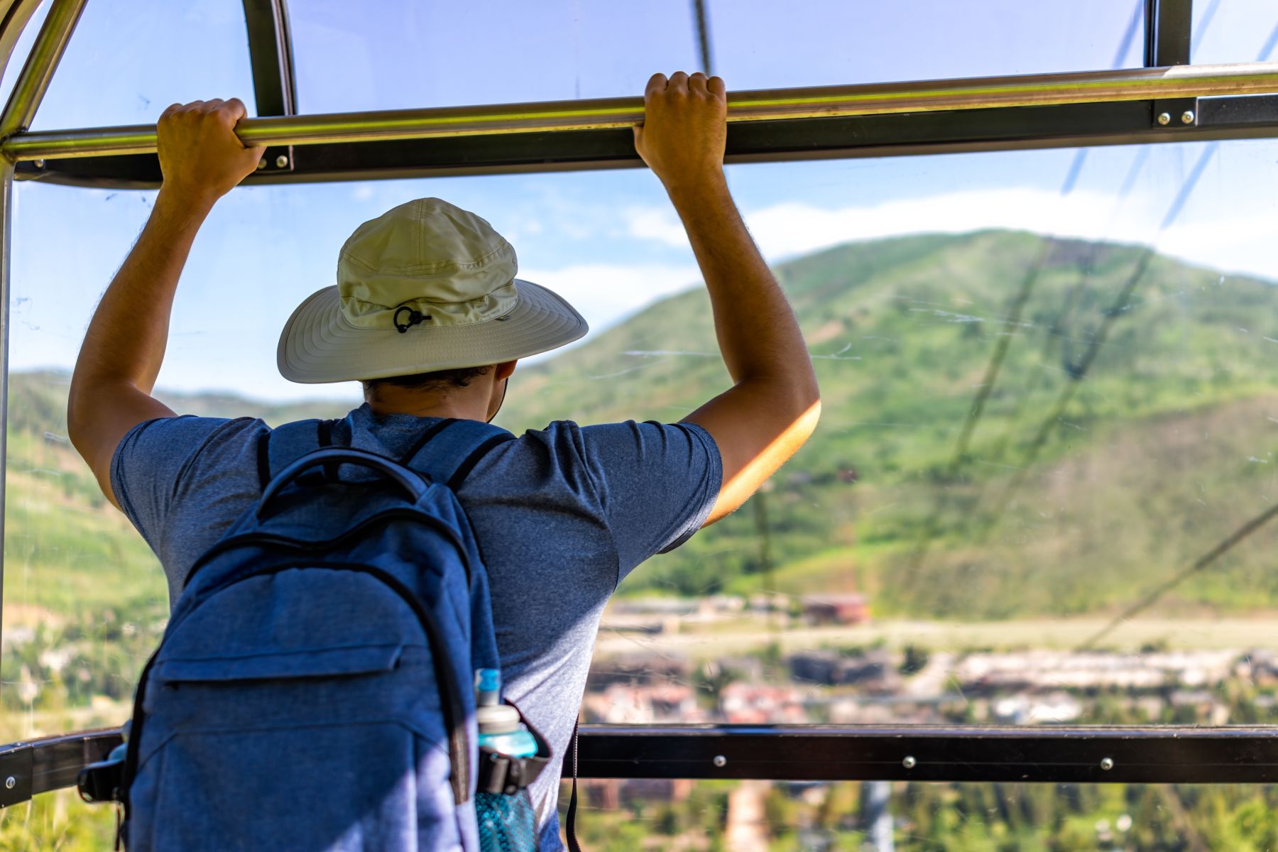 man looking at mountains from gondola